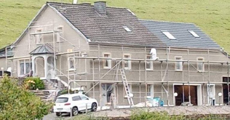 Haussanierung zeigt ein Einfamilienhaus mit Gerüst